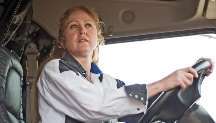 Female truck driver checking her side mirrors